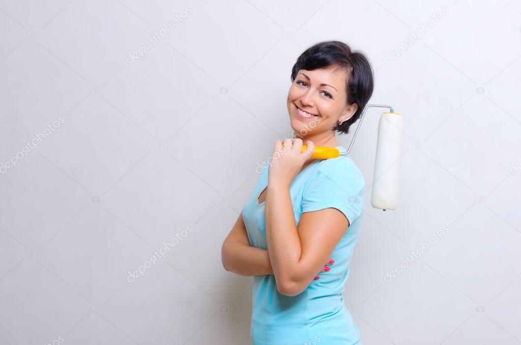 Young woman with painting roller