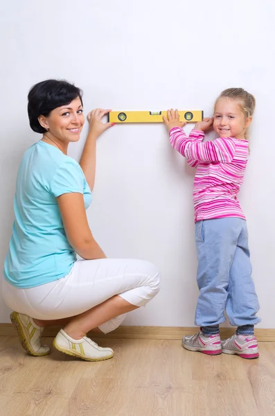 Mujer y niña con nivel de medición — Foto de Stock