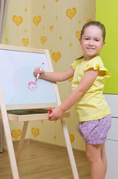 Girl draws a marker on white board — Stock Photo, Image
