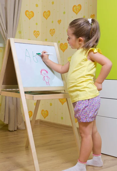 Girl draws a marker on white board — Stock Photo, Image