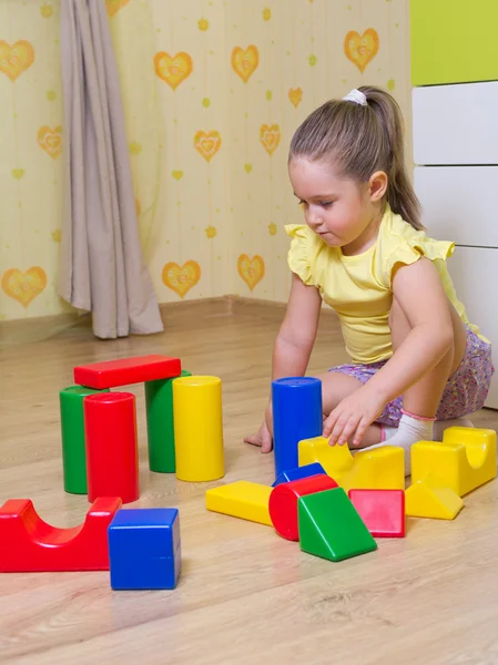 Mädchen spielt mit Plastikwürfeln lizenzfreie Stockbilder