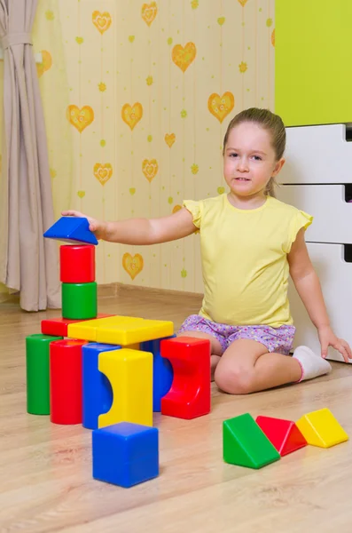 Mädchen spielt mit Plastikwürfeln Stockbild