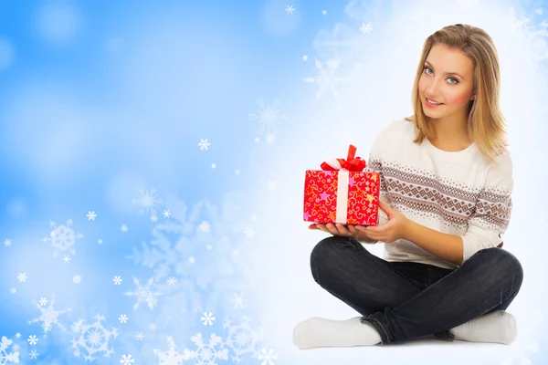 Young woman with gift boxes on snowy background — Stock Photo, Image