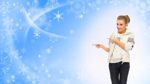 Young girl shows pointing gesture on winter background — Stock Photo, Image