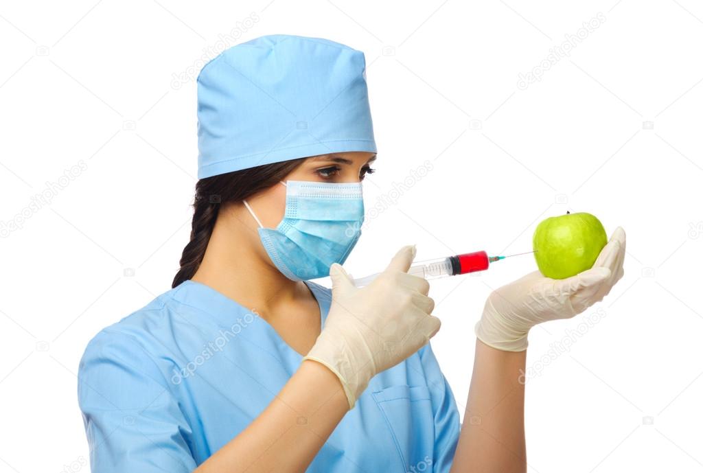 Young doctor with syringe and apple