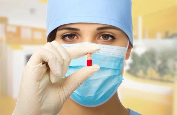 Young doctor holding red pill — Stock Photo, Image
