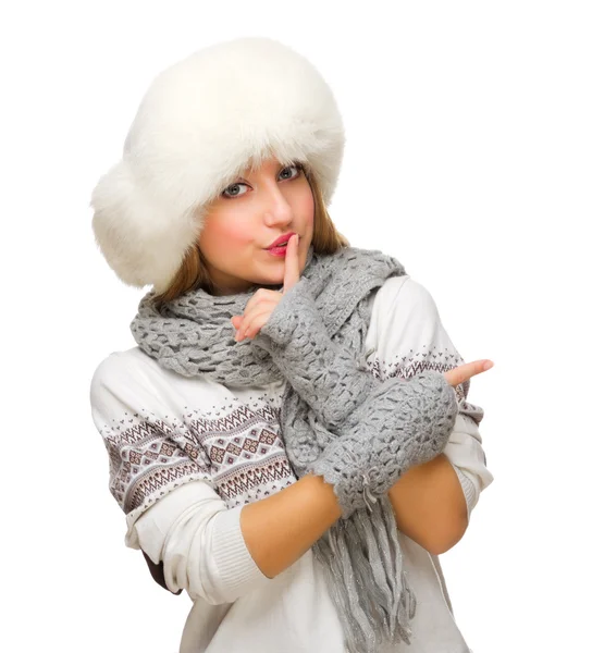 Young smiling girl in white sweater showing pointing gesture — Stock Photo, Image