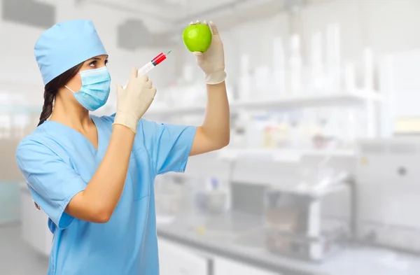 Young doctor with syringe and apple — Stock Photo, Image