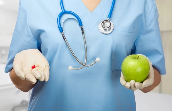 Doctor with pill and apple — Stock Photo, Image