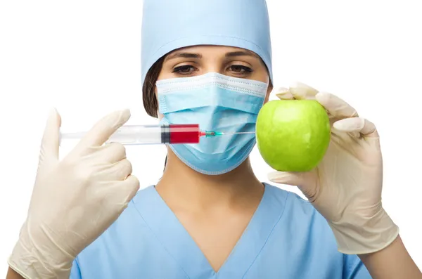 Doctor with syringe and apple — Stock Photo, Image