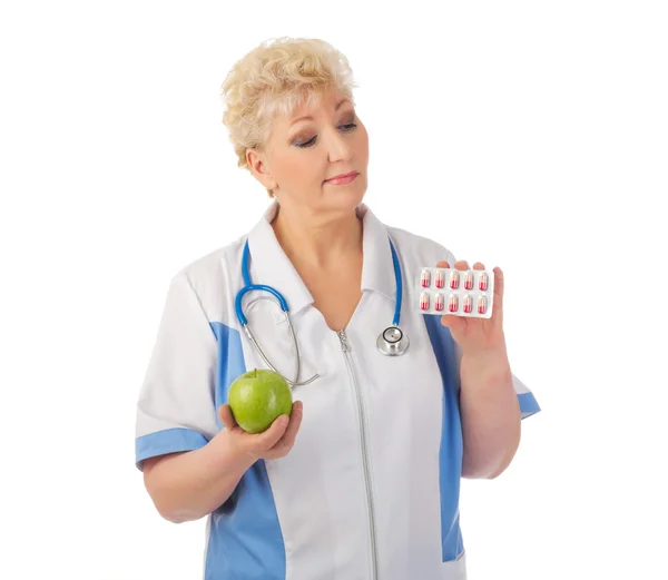 Médico maduro com maçã e pílulas — Fotografia de Stock