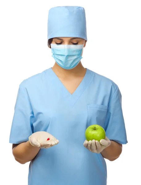 Доктор с таблетками и яблоком — стоковое фото