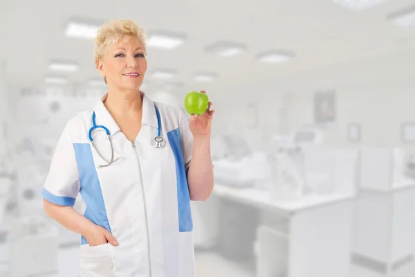 Reife Ärztin mit grünem Apfel — Stockfoto