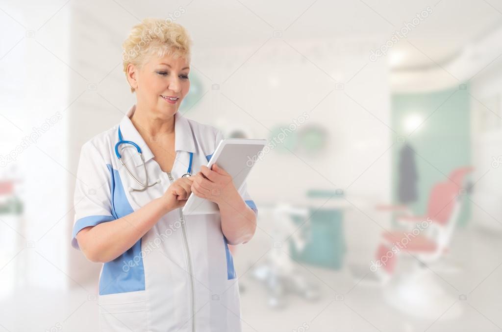 Mature doctor with tablet PC