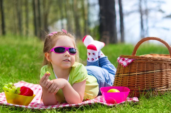 Little girl eating grapes at picnic — Stock Photo, Image