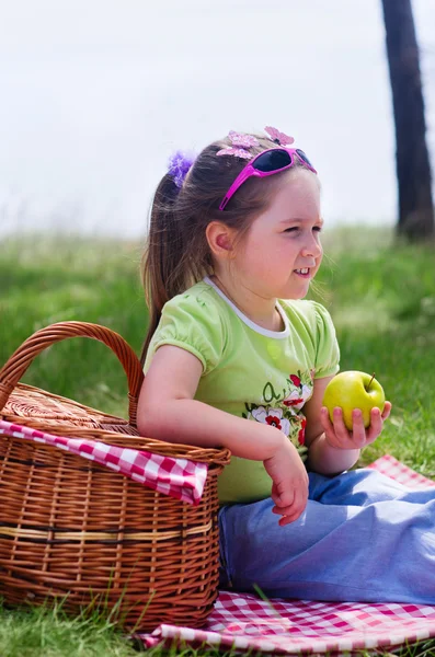 Liten flicka med picknickkorg och äpple — Stockfoto