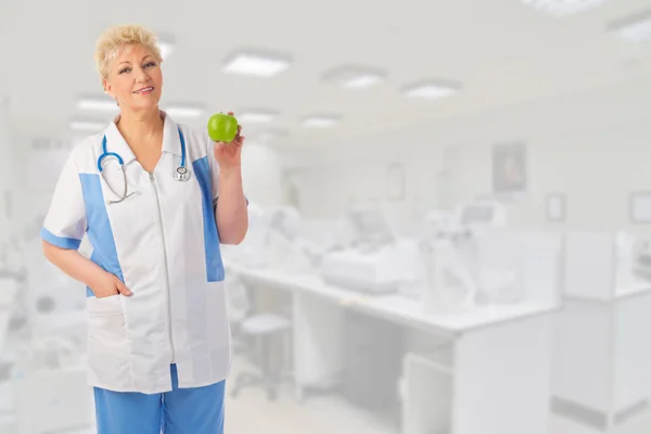 Mature doctor with apple — Stock Photo, Image