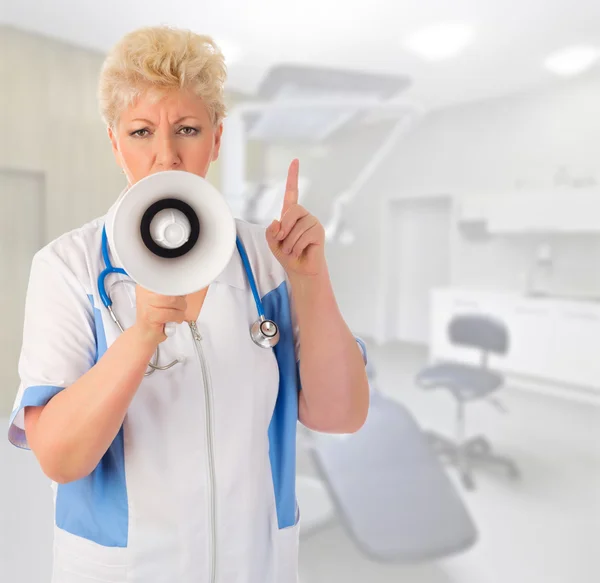 Mature doctor with megaphone — Stock Photo, Image