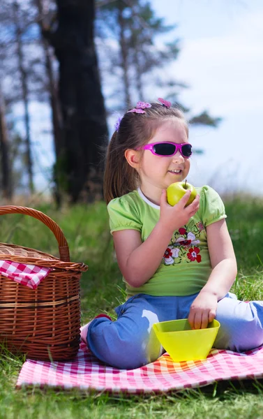 Little girl with apple and picnic basket — Stock Photo, Image