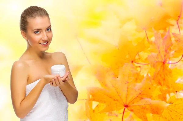 Young girl with body cream on autumnal background — Stock Photo, Image