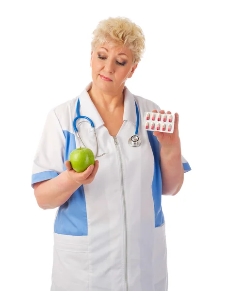 Mature doctor with apple and pills — Stock Photo, Image