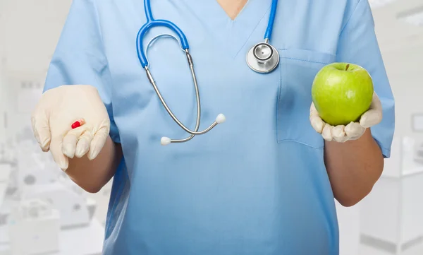 Médico con píldora y manzana — Foto de Stock