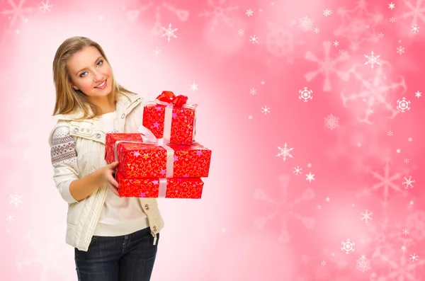 Chica con cajas de regalo sobre fondo rojo nevado —  Fotos de Stock