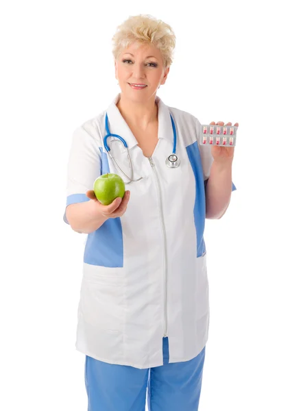 Mature doctor with apple and pills — Stock Photo, Image