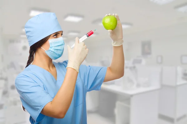 Биохимик со шприцем и яблоком — стоковое фото