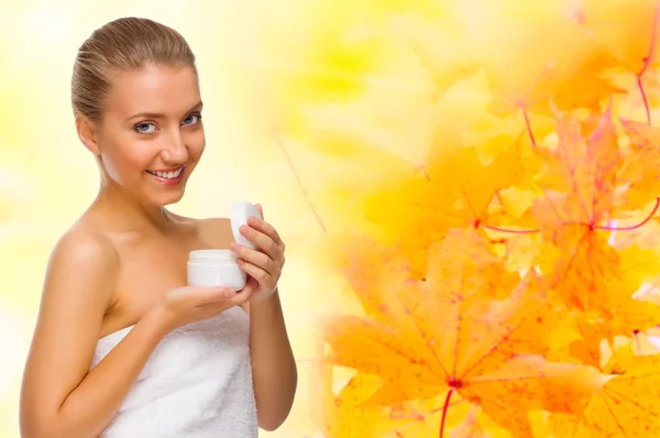 Young girl with body cream on autumnal background — Stock Photo, Image