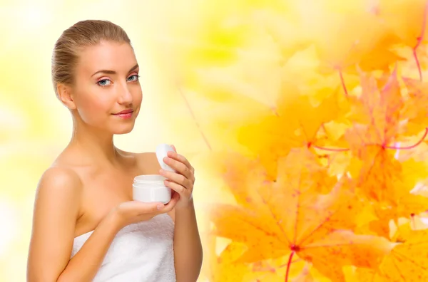 Young girl with body cream on autumnal background — Stock Photo, Image