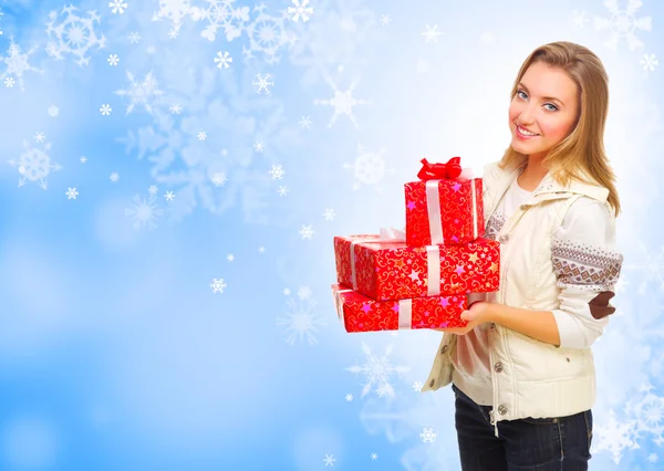Giovane ragazza con scatole regalo su sfondo invernale — Foto Stock