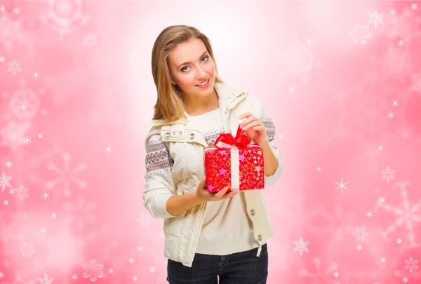 Young smiling girl with gift box on winter background — Stock Photo, Image