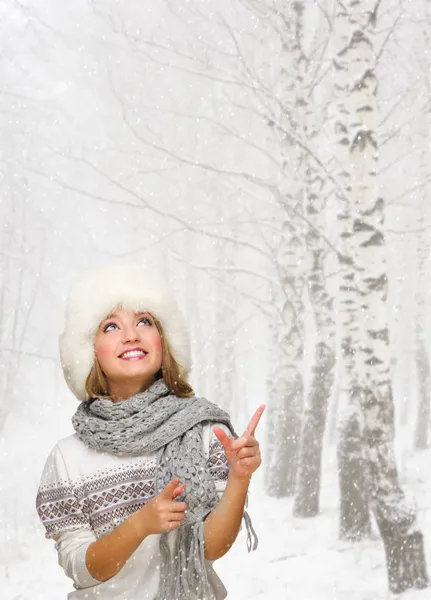 Girl shows pointing gesture at winter forest — Stock Photo, Image
