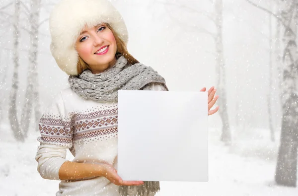 Young girl with empty card at snowy forest — Stock Photo, Image