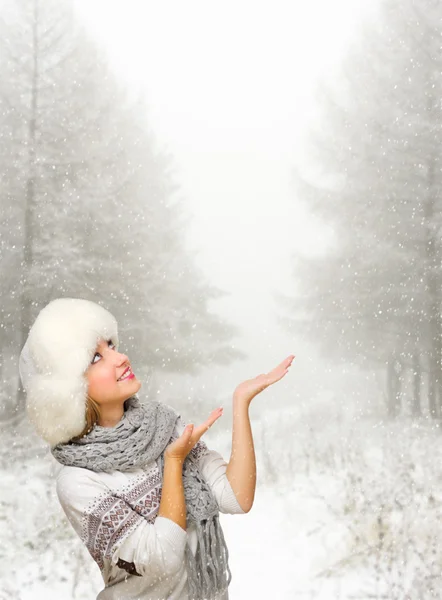 Young girl shows pointing gesture at snowy forest — Stock Photo, Image