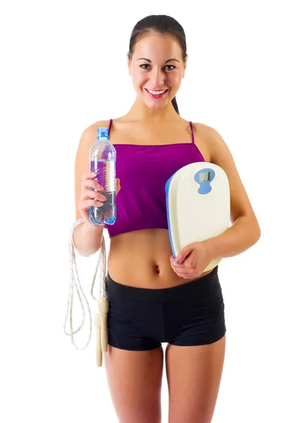 Young sporty woman with water bottle and scales — Stock Photo, Image