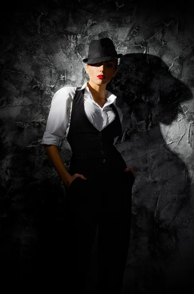 Portrait of young woman in hat on wall — Stock Photo, Image