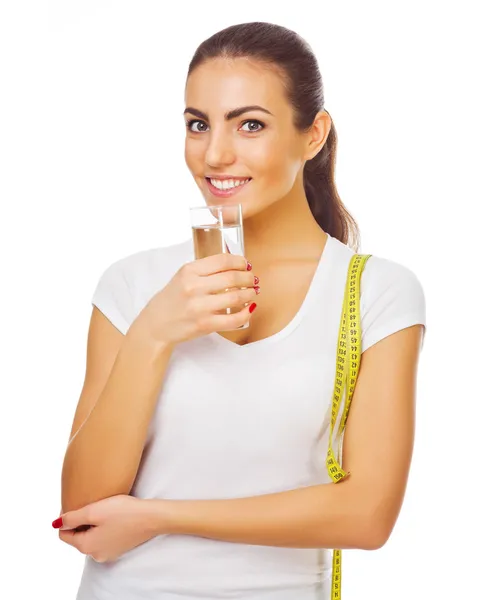 Joven chica deportiva con cinta métrica y vaso de agua — Foto de Stock