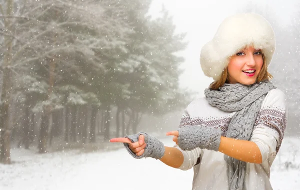 Young girl at snowy forest shows pointing gesture — Stock Photo, Image