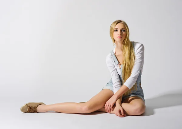 어린 소녀 회색에 바닥에 앉아 — 스톡 사진