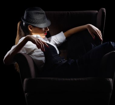 sandalye üzerinde erkekçe tarzı genç kadın portresi