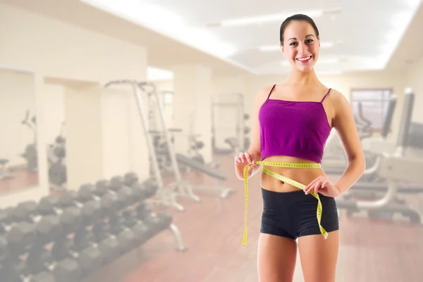 Young girl with centimeter tape at gym club — Stock Photo, Image