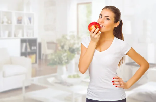 Chica con manzana en la sala de luz — Foto de Stock