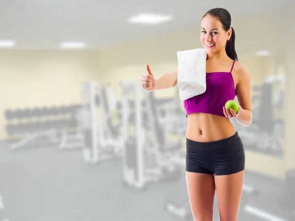 Flicka med handduk och apple på gymmet club — Stockfoto
