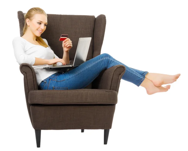 Young girl with plastic card and laptop on chair — Stock Photo, Image