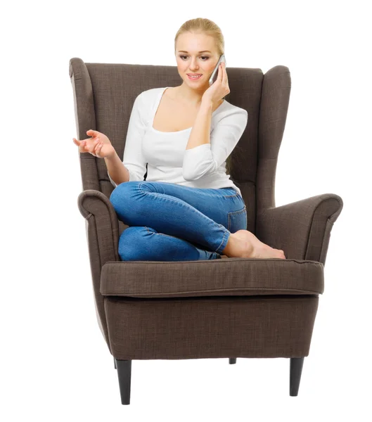 Молодая девушка с мобильным телефоном в кресле — стоковое фото