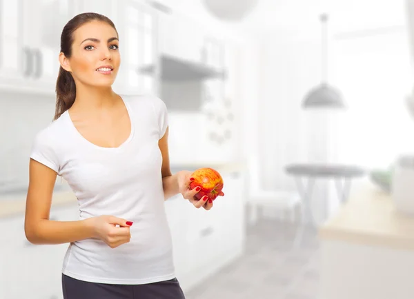 Chica joven con manzana en la sala de luz — Foto de Stock