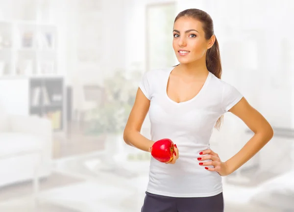 Chica con manzana en la sala de luz — Foto de Stock