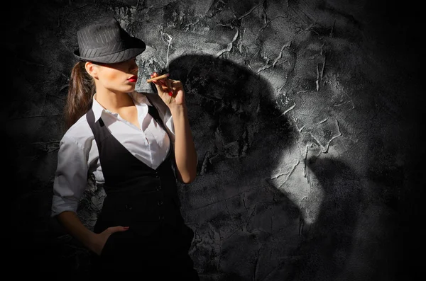 Mujer con cigarro en pared gris — Foto de Stock